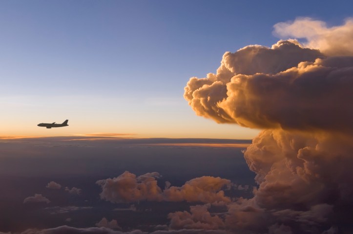 Top view of an airplane flying near a storm front